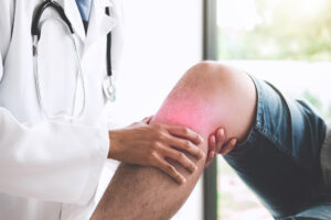 Doctor examining patient with knee pain